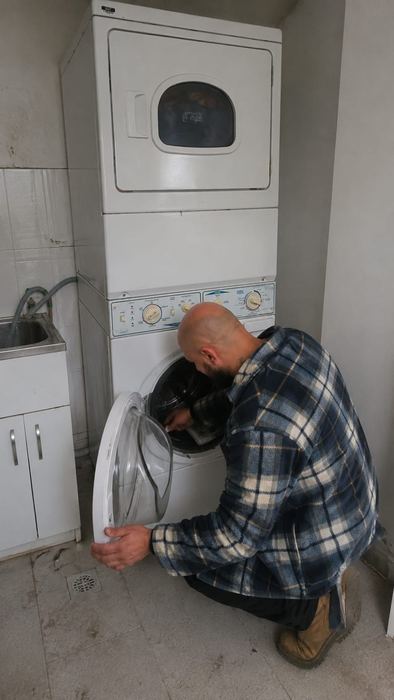 Technician inspecting a front-load dryer drum